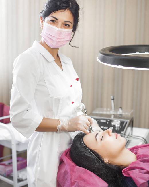 Doctor makin a procedure of microdembrasion to her patient. Skin cleaning procedure. Face care. Cosmetologist making apparatus peeling, exfoliation. Close up still of skin treatment in the beauty clinic or salon.